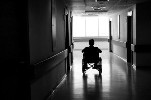 Elderly man sitting alone in empty hallway