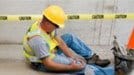 man on ground near cone holding knee