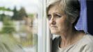Older lady staring out window in nursing home