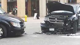 Two black vehicles with smashed front ends after a collision