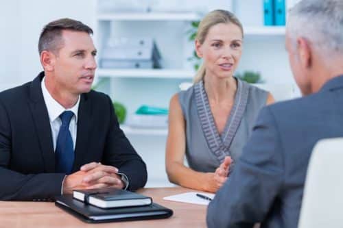 woman attorney with man and woman clients sitting at table