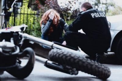 Police officer talking to motorcyclist after accident