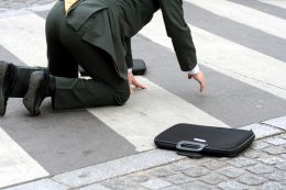 man in suit rising from fall on crosswalk