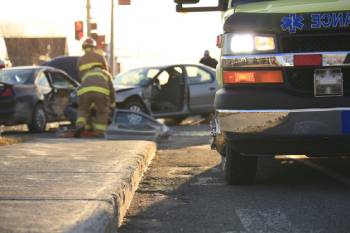 Close-up of ambulance with car accident and paramedics in background