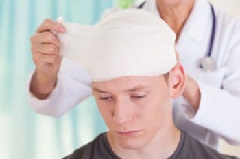 Sad young man with head trauma bandage