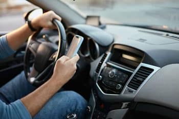 Close-up of a man using his phone while driving